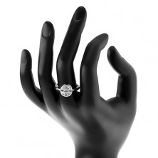 Sijoč prstan srebrne barve, krog, okrašen s prozornimi zrni in okroglim cirkonom
